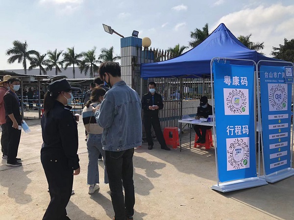 工作人員在入口指引群眾有序掃碼測溫.jpg