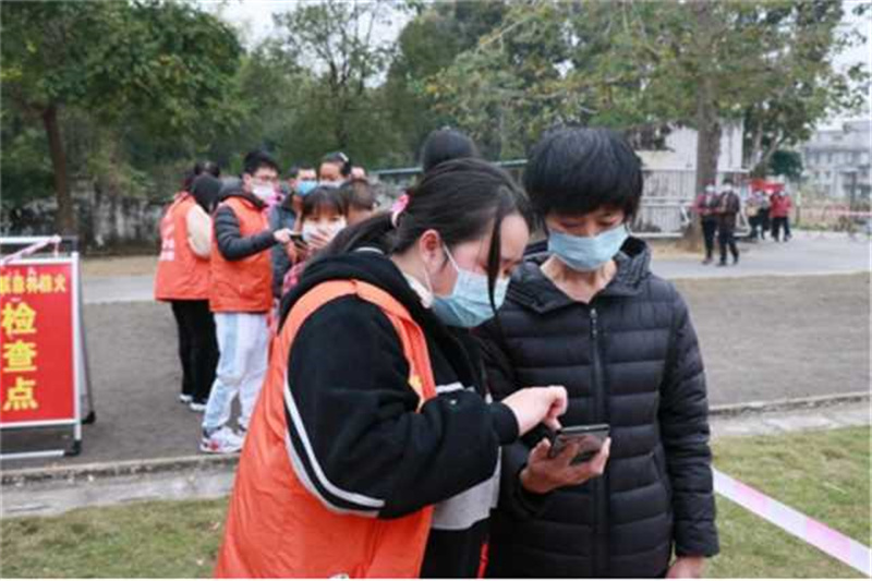 圖五：黃家寶在核酸現(xiàn)場(chǎng)幫助群眾完成信息登記，生成葵花碼（攝影者：劉綺婷，單位：三合鎮(zhèn)人民政府）.jpg